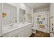 Well-lit bathroom with a double sink vanity, wood-look flooring and a shower with a decorative curtain at 433 Cedarview Rd, Summerville, SC 29486