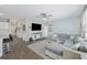 Open-concept living room with plush sectional sofa, ceiling fan, wall-mounted TV, and seamless flow to the kitchen at 433 Cedarview Rd, Summerville, SC 29486