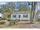 Charming single-story home with white siding, blue shutters and lush front landscaping at 4816 Chesterfield Rd, North Charleston, SC 29405