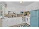 Galley kitchen includes white cabinets, stainless steel sink, and vintage appliances at 4816 Chesterfield Rd, North Charleston, SC 29405
