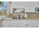 Classic kitchen featuring stainless steel double sink, white cabinetry, and natural light at 4816 Chesterfield Rd, North Charleston, SC 29405