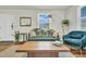 Living room showcasing a decorative green couch, wooden floors, and bright, natural lighting at 4816 Chesterfield Rd, North Charleston, SC 29405