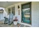 Cozy front porch with rocking chair and potted plants on a quaint brick home at 5332 Parkside Dr, North Charleston, SC 29405