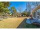 Expansive backyard with well-kept lawn, bordered by mature trees and a storage shed in the distance at 613 Salterton St, Summerville, SC 29485