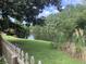 Scenic backyard featuring a tranquil pond view and lush greenery, enhanced by the frame of a white picket fence at 613 Salterton St, Summerville, SC 29485