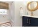 Bathroom featuring modern vanity with gold faucet and hardware, round mirror, and shower with curtain at 707 Palmetto Blvd, Edisto Island, SC 29438