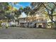 Stilt house with a cozy porch and backyard featuring lush trees, creating a serene outdoor living space at 707 Palmetto Blvd, Edisto Island, SC 29438