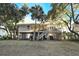 Rear exterior stilt house boasts screened porch and deck overlooking landscaped yard, blending comfort and nature at 707 Palmetto Blvd, Edisto Island, SC 29438