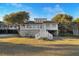 Charming coastal home with a white exterior, elevated design, and beautiful landscaping on a sunny day at 707 Palmetto Blvd, Edisto Island, SC 29438