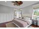 A well-lit main bedroom showcasing hardwood floors, a decorative ceiling fan, and a view into an ensuite bathroom at 720 Island Park Dr # 104, Charleston, SC 29492