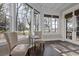Bright sunroom with floor-to-ceiling windows, a bistro table set, and views of the outdoor landscape at 720 Island Park Dr # 104, Charleston, SC 29492