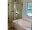 Bright bathroom with shower with glass door and a soaking tub at 7753 Blue House Ln, Edisto Island, SC 29438
