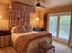 Primary bedroom with canopy bed, ceiling fan, and access to a private balcony at 7753 Blue House Ln, Edisto Island, SC 29438