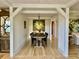 Elegant dining room features wood floors, a modern chandelier, and white wooden beam columns at 7753 Blue House Ln, Edisto Island, SC 29438
