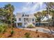 Stylish coastal home with a double staircase, blue shutters, and a well-maintained yard at 806 Jungle Rd, Edisto Island, SC 29438