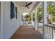 Inviting front porch with a ceiling fan and wooden deck overlooks the peaceful neighborhood at 806 Jungle Rd, Edisto Island, SC 29438