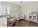 Cozy Bedroom features a white crib, comfortable chair, and whimsical wall decals, creating a warm atmosphere at 8209 Governors Walk, North Charleston, SC 29418