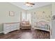 This bedroom features unique murals on the walls, a crib and dark wood flooring at 8209 Governors Walk, North Charleston, SC 29418