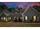 Charming single-story home at dusk featuring a neatly landscaped yard, inviting lights, and a welcoming facade at 8209 Governors Walk, North Charleston, SC 29418