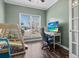 This home office features a ceiling fan, lots of light and light green walls at 8209 Governors Walk, North Charleston, SC 29418
