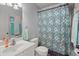 Cozy bathroom featuring a patterned shower curtain, white vanity, and ample lighting at 8696 Spring Chapel Ln, North Charleston, SC 29420