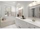 Bright bathroom with double vanity, soaking tub, and a large window at 8696 Spring Chapel Ln, North Charleston, SC 29420