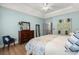 Spacious bedroom with wood flooring, traditional dresser, and a comfortable accent chair at 8696 Spring Chapel Ln, North Charleston, SC 29420