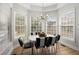 Bright dining room featuring large windows, modern lighting fixture and table with black and white striped chairs at 8696 Spring Chapel Ln, North Charleston, SC 29420