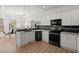 Open kitchen with white cabinets, granite countertops, stainless steel appliances, and a view of the dining area at 8696 Spring Chapel Ln, North Charleston, SC 29420