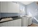 Bright laundry room with cabinets, counter, sink, washer, and dryer in a home at 8696 Spring Chapel Ln, North Charleston, SC 29420