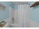 Bright bathroom featuring a shower-tub combo, blue walls and white wainscoting at 9021 Robins Nest Way, Summerville, SC 29485