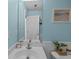 Bright bathroom featuring blue walls, white vanity, modern fixtures and coastal themed decor at 9021 Robins Nest Way, Summerville, SC 29485