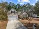 Inviting home featuring a one car garage, American flag, neutral siding and mature trees at 9021 Robins Nest Way, Summerville, SC 29485