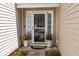 Close-up of a tidy front door with charming plants and a decorative welcome mat at 9021 Robins Nest Way, Summerville, SC 29485