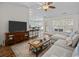 Bright living room features a comfortable sofa, ceiling fan, and open access to the dining area at 9021 Robins Nest Way, Summerville, SC 29485