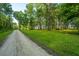 Gravel road leading to a wooded community with lush trees and green grass at 9207 Bowen Corner Ave, Hanahan, SC 29410