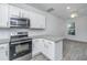 Bright modern kitchen with white cabinets, granite countertops, and stainless steel appliances at 9207 Bowen Corner Ave, Hanahan, SC 29410