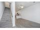 Bright living room features gray flooring, a staircase, and a view of the modern kitchen at 9207 Bowen Corner Ave, Hanahan, SC 29410