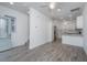 Bright living room features gray flooring, a staircase, an entry door, and a modern kitchen at 9207 Bowen Corner Ave, Hanahan, SC 29410