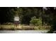 A charming pond with a small, elevated structure, surrounded by lush greenery and mature trees at 1010 Swamp Rose Run, Summerville, SC 29485
