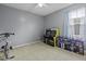 Bedroom with grey walls, carpeted floor, and filled with two arcade games and an exercise bike at 107 Diploma Dr, Ladson, SC 29485