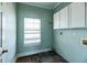 Functional laundry room with stone flooring, window, and ample upper cabinetry for storage at 109 Walnut Creek Rd, Charleston, SC 29414
