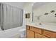Bright bathroom featuring a shower with gray curtain, wood cabinets, and fish decorations at 1106 Barfield St, Charleston, SC 29492
