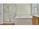 Bright bathroom features a glass shower, soaking tub, and wood floors at 1106 Barfield St, Charleston, SC 29492