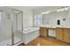 Luxurious bathroom with a soaking tub, walk-in shower, dual vanities, and wood floors at 1106 Barfield St, Charleston, SC 29492