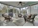 Relax on this screened-in porch featuring comfortable wicker furniture, a ceiling fan, and serene outdoor views at 1106 Barfield St, Charleston, SC 29492