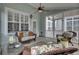 Enjoy this screened-in porch featuring comfortable wicker furniture, a ceiling fan, and serene outdoor views at 1106 Barfield St, Charleston, SC 29492
