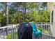 Relaxing back deck with a grill and a chair overlooking lush trees at 1204 Basildon Rd, Mount Pleasant, SC 29466
