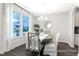 Bright dining room features a round table, four upholstered chairs, large windows and modern light fixture at 1233 Homecoming Blvd # Cc2-1-34, Ravenel, SC 29470