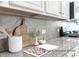 Close-up of granite countertops with stylish backsplash, modern appliances, and elegant decor at 1233 Homecoming Blvd # Cc2-1-34, Ravenel, SC 29470